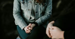 a woman sitting holding her hands