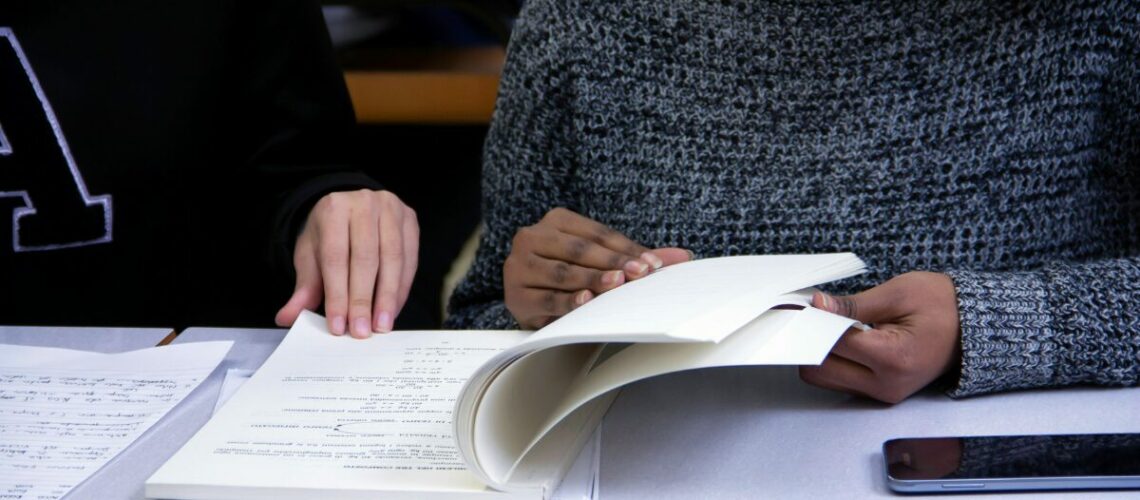 two people studying a textbook