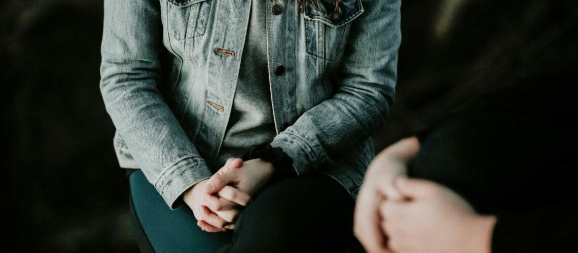 a woman sitting holding her hands